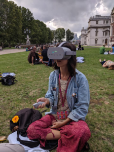 A student sits cross-legged while wearing an Oculus Go headset