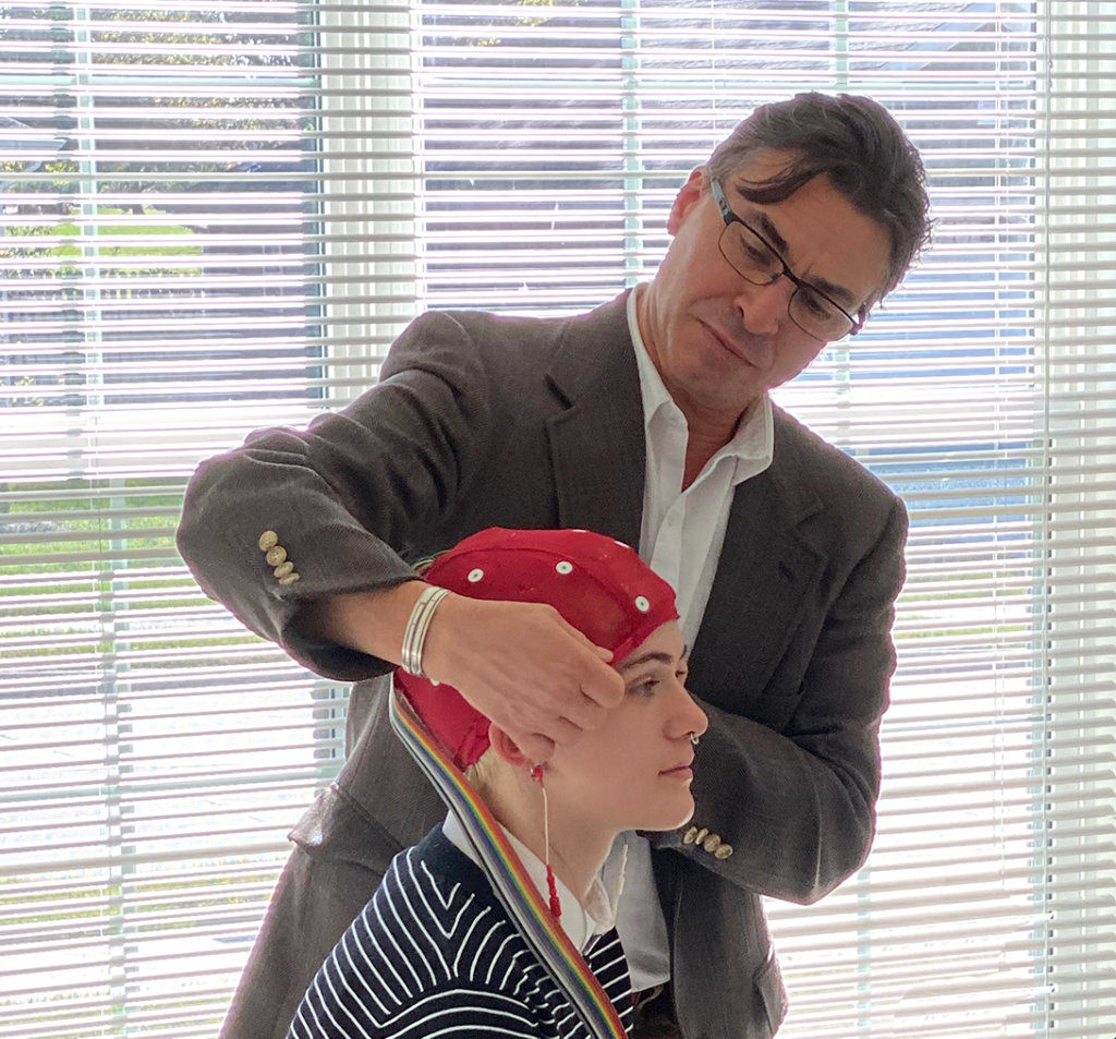 Jeff and Annarose demonstrate how an EEG cap is worn on the head